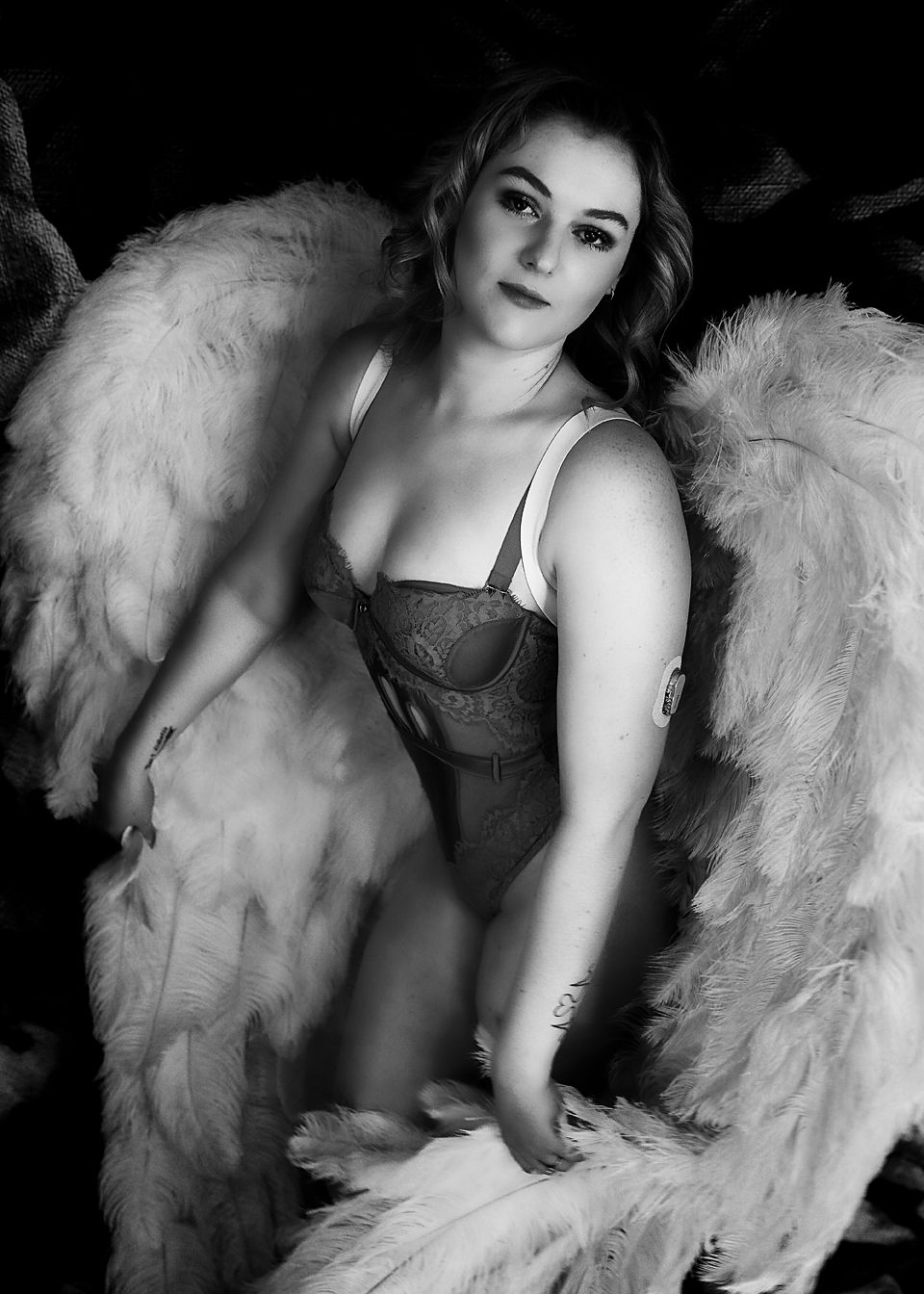 A black and white artistic photo series featuring a model posing with elegant white feathered wings.