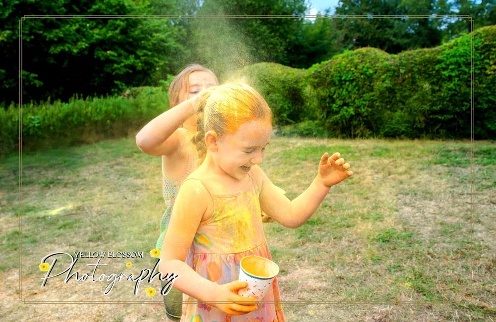 Yellow powder explodes around a participant during a vibrant color festival celebration.