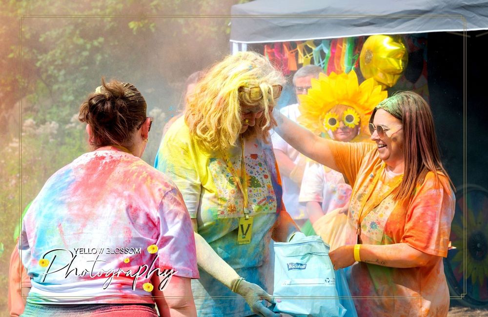Colorful powder fills the air as festival-goers celebrate with bright hues against a dark background.