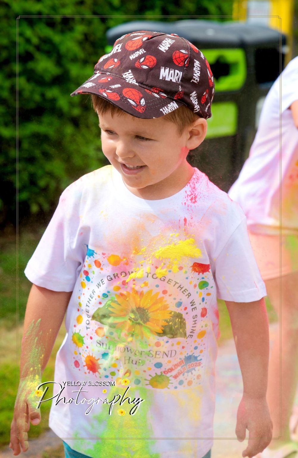 White t-shirt decorated with vibrant splashes of colorful powder paint and decorated with playful designs.