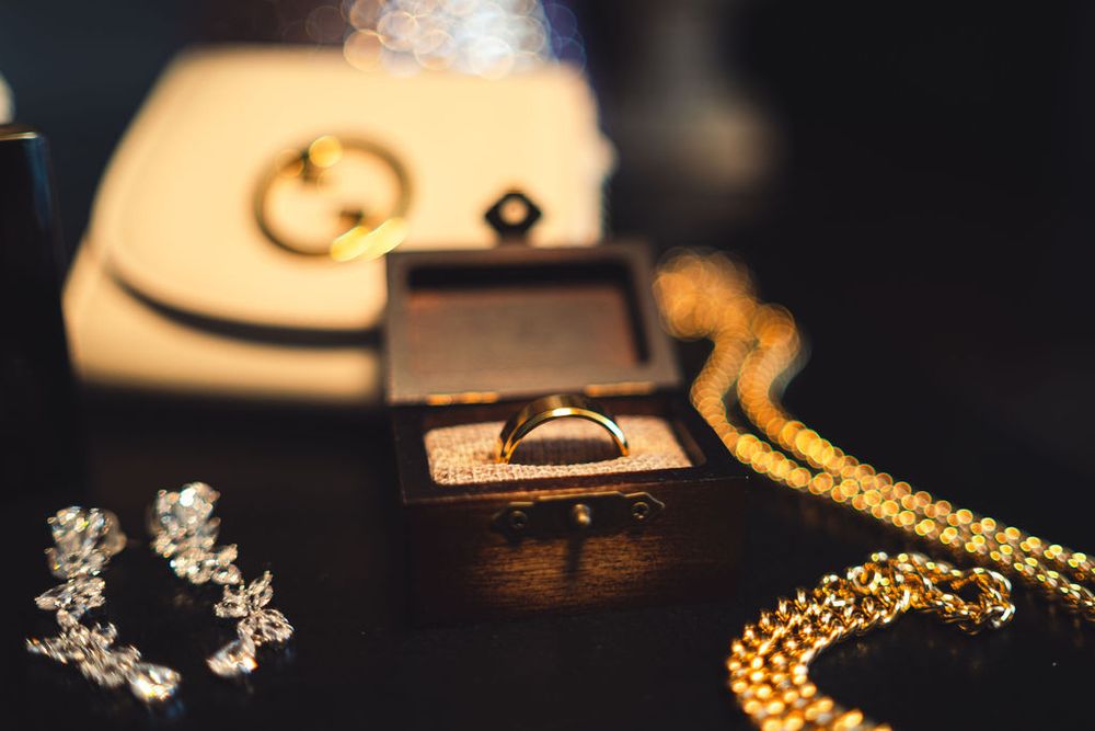 Elegant close-up of bridal jewelry including golden necklaces, earrings, and accessories on a dark background.