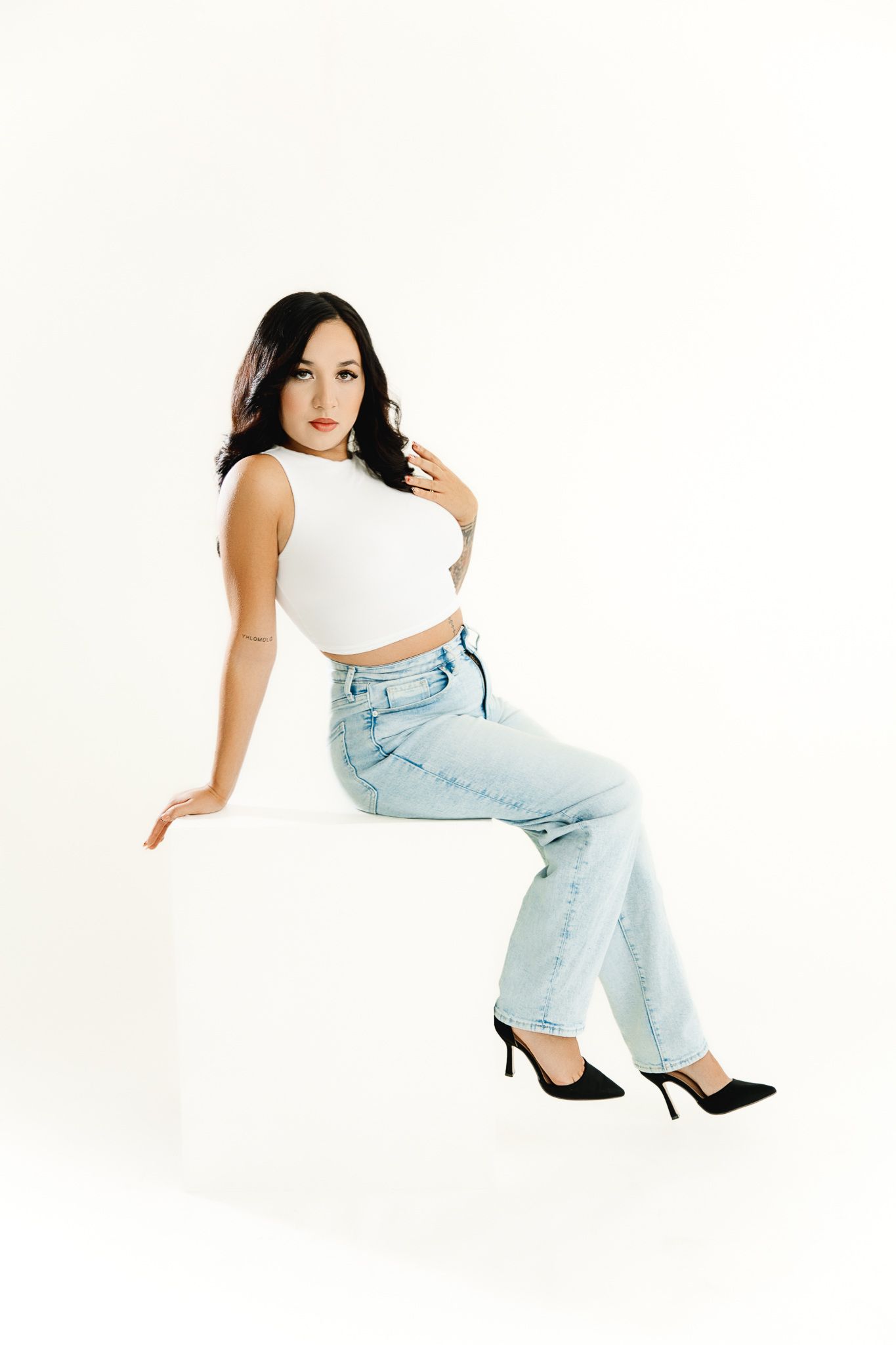 Studio birthday photoshoot of a girl posing on a posing block while she celebrates her 23rd birthday in a Windsor colorado studio.