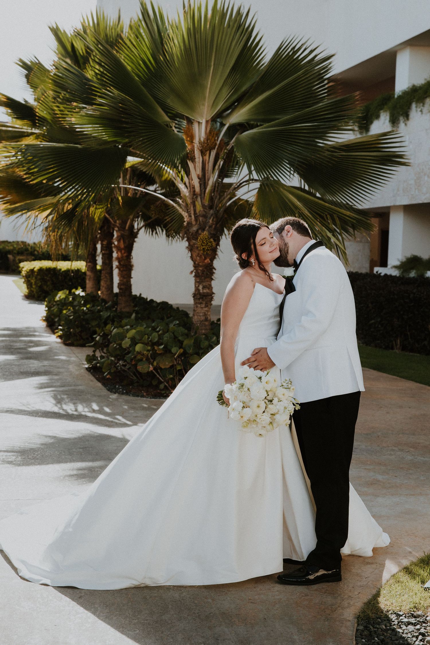 A romantic wedding moment captured under swaying palm trees at dreams macao resort
