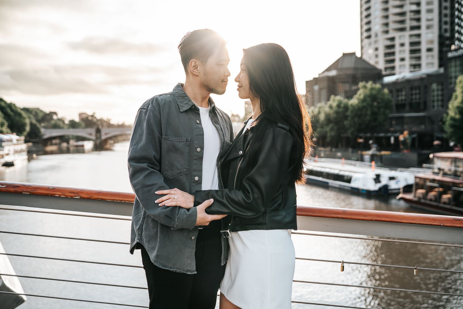 Couple sharing romantic moment on waterfront deck during golden hour taken by Melbourne casual couples and engagement photographer.