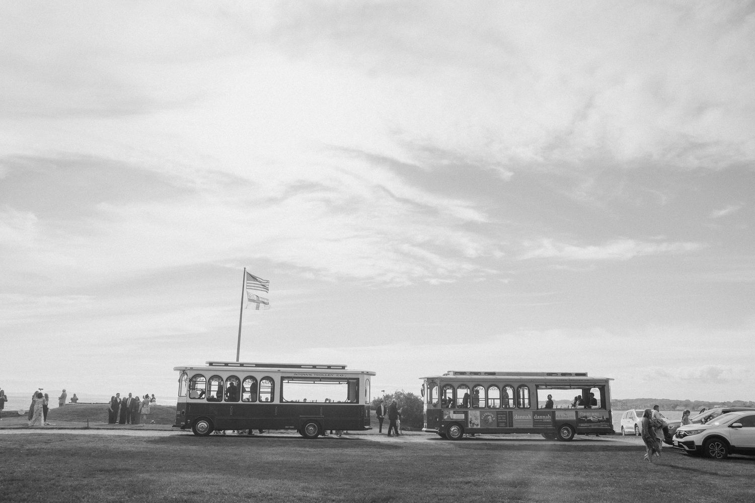 Vintage trolley cars parked at a scenic overlook under cloudy skies.