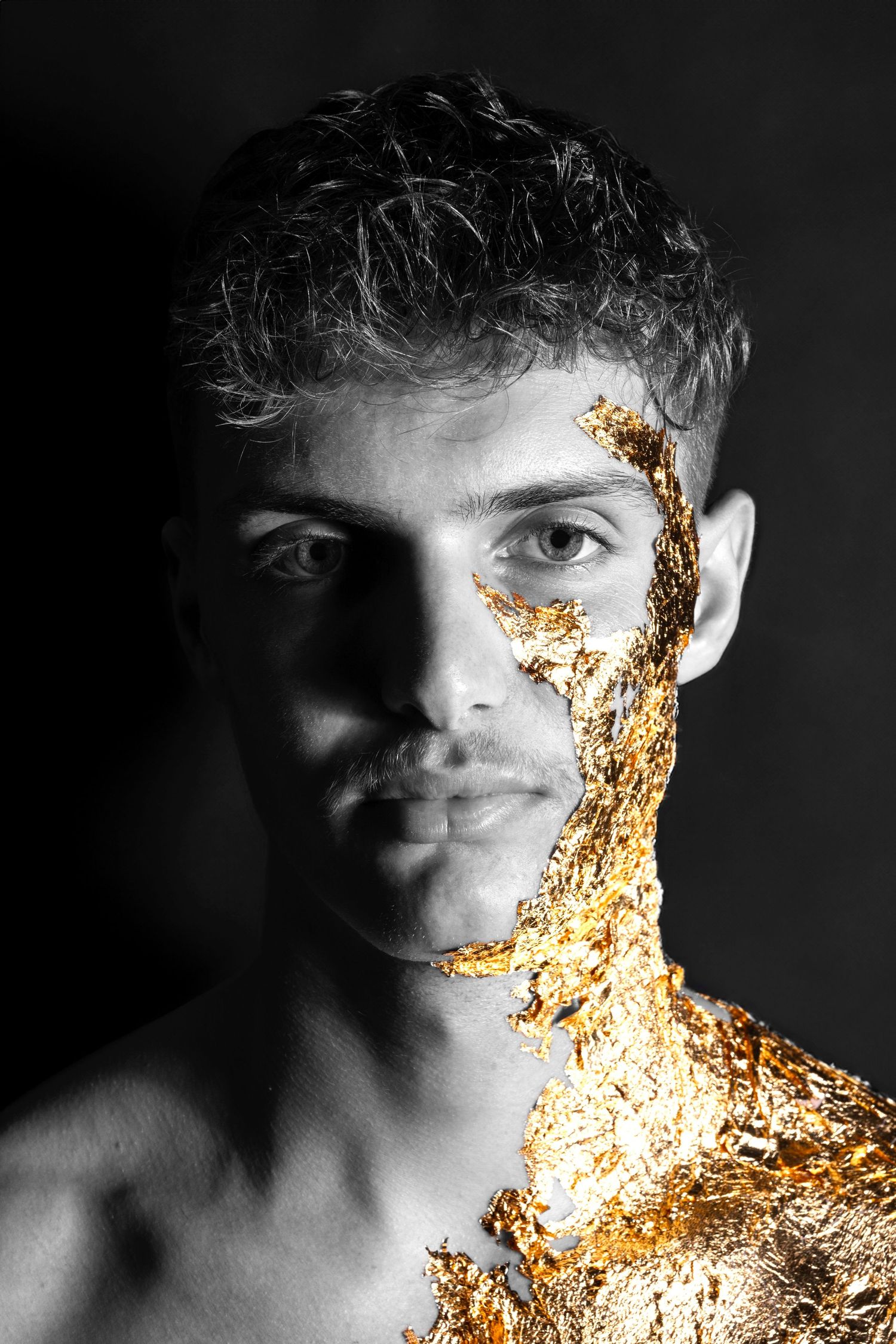 Creative black and white portrait featuring gold leaf metallic effect overlay on model creating dramatic contrast.