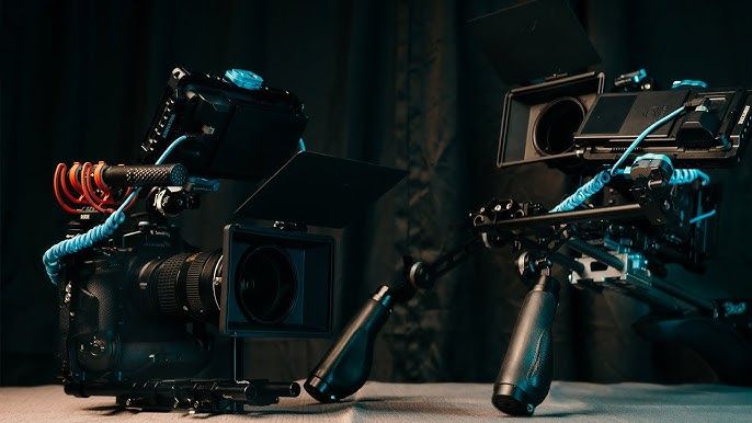 Professional video cameras and equipment arranged in a dark studio setting.