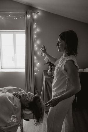 A series of black and white photos showing someone getting ready in a room decorated with string lights.