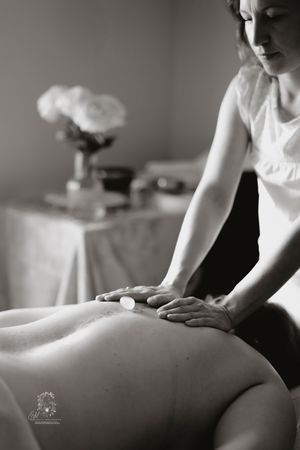 A massage therapist performs a professional therapeutic massage treatment on a client in a spa setting.