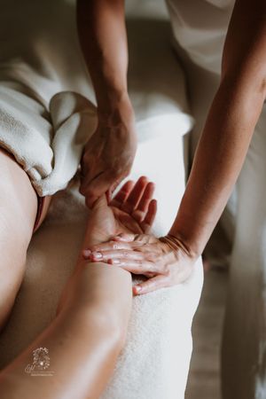 Professional massage therapist performs therapeutic massage techniques on client's back at luxury spa.