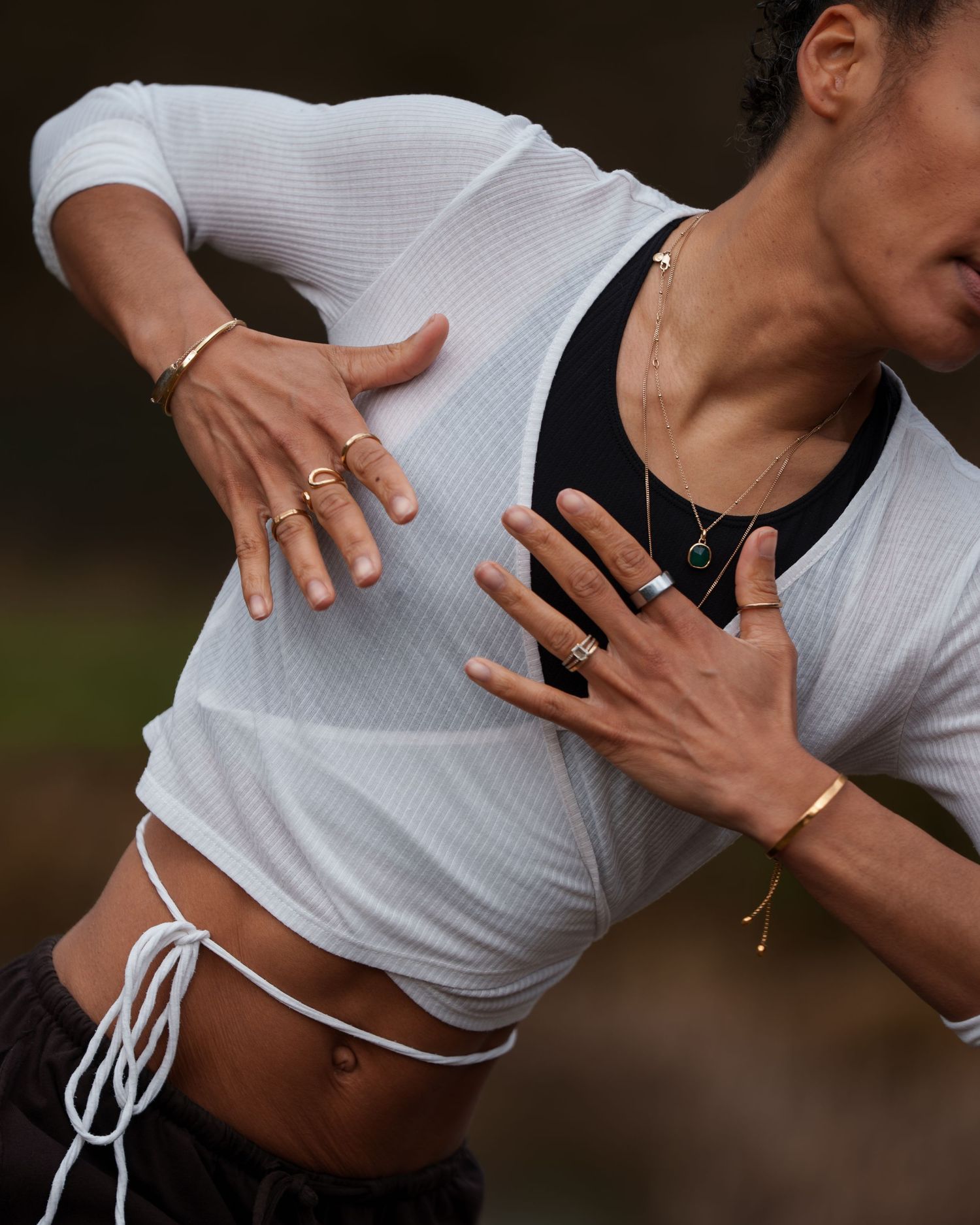 Woman performing a side plank yoga pose outdoors, wearing dark athletic shorts and sports bra.