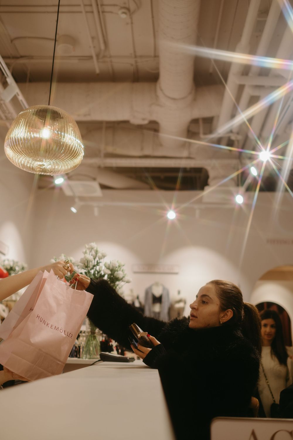 woman shopping at clothing store while being captured by fashion event photographer in Stockholm during store launch event
