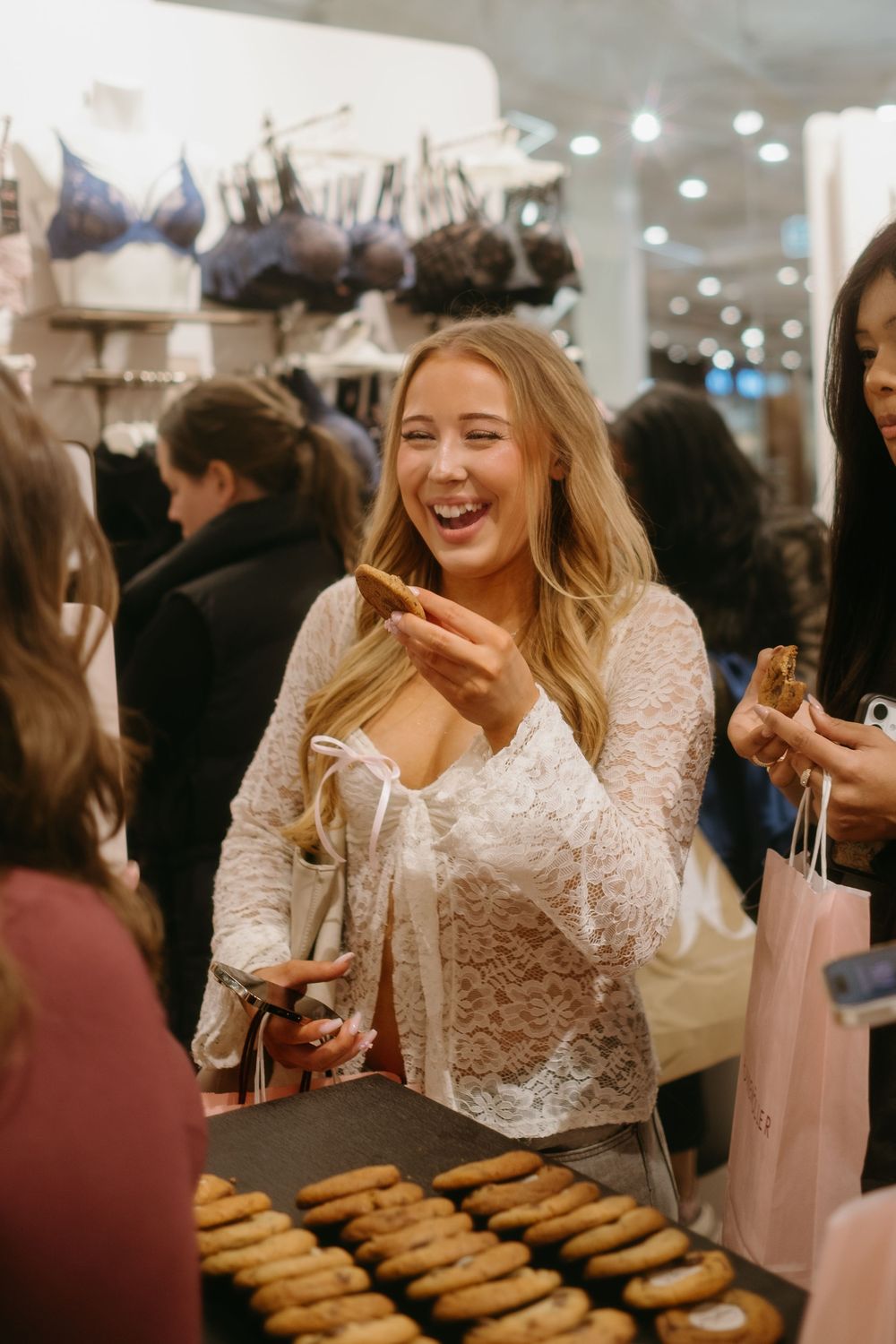 woman laughing taking a cookie during brand event in Stockholm while being captured by lifestyle brand photographer