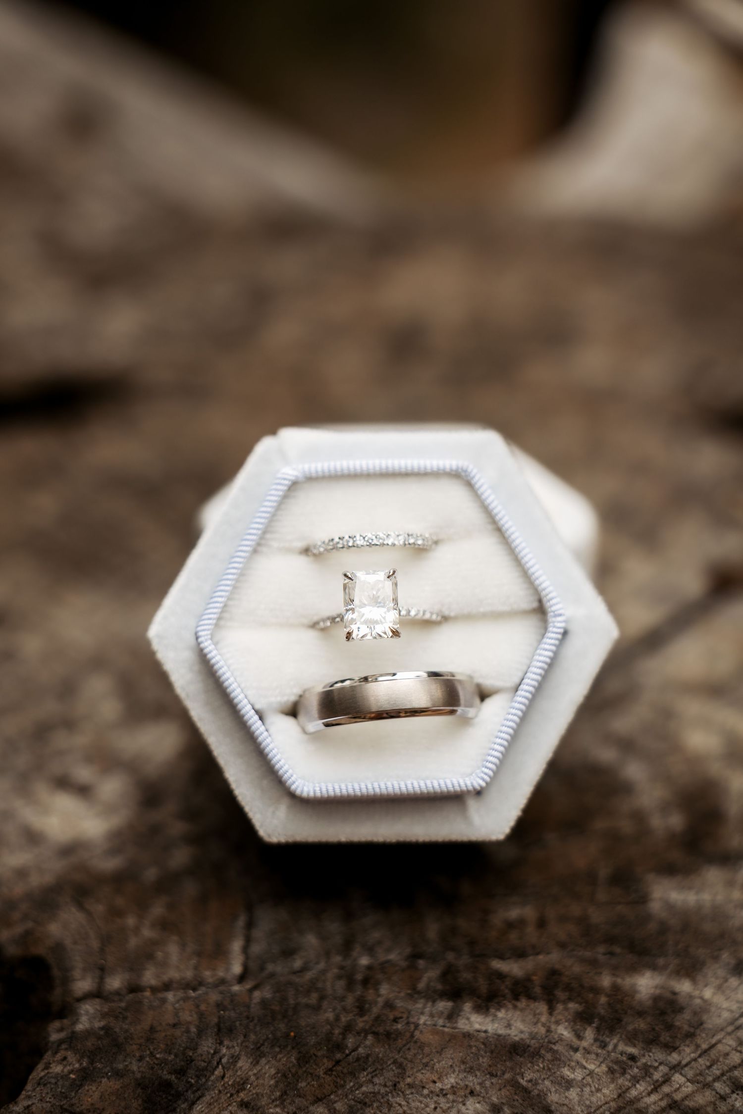 Macro detail shot of an engagement ring resting on a textured surface, capturing the fine details of a wedding story.