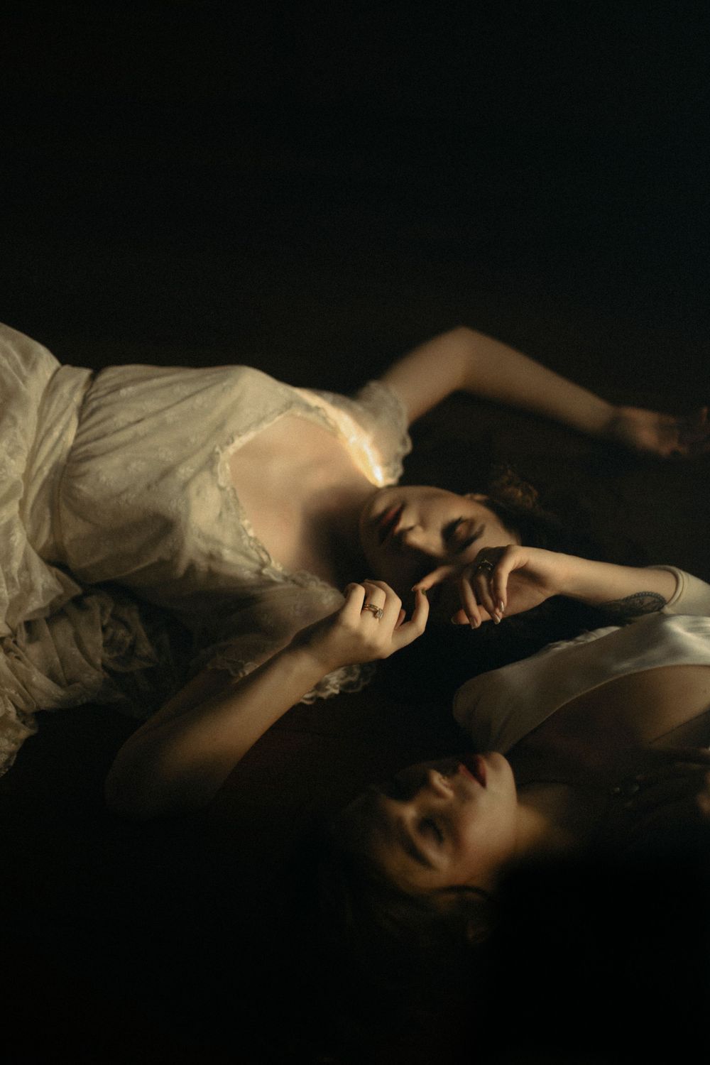 Dramatic low-light portrait with flowing white fabric in darkness captured by a destination elopement photographer.