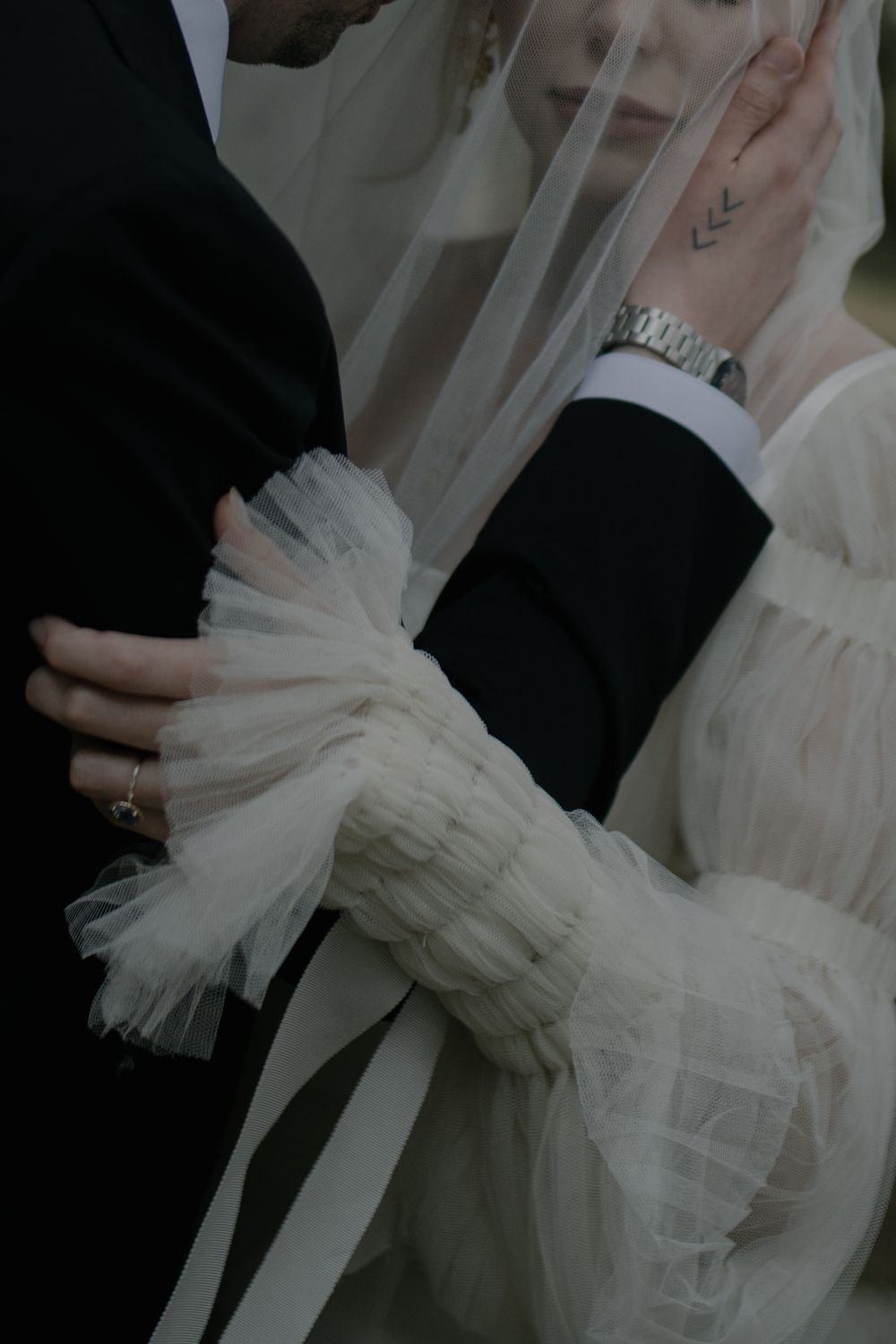 Wedding couple in black and white with flowing white tulle dress details captured by a destination elopement photographer.