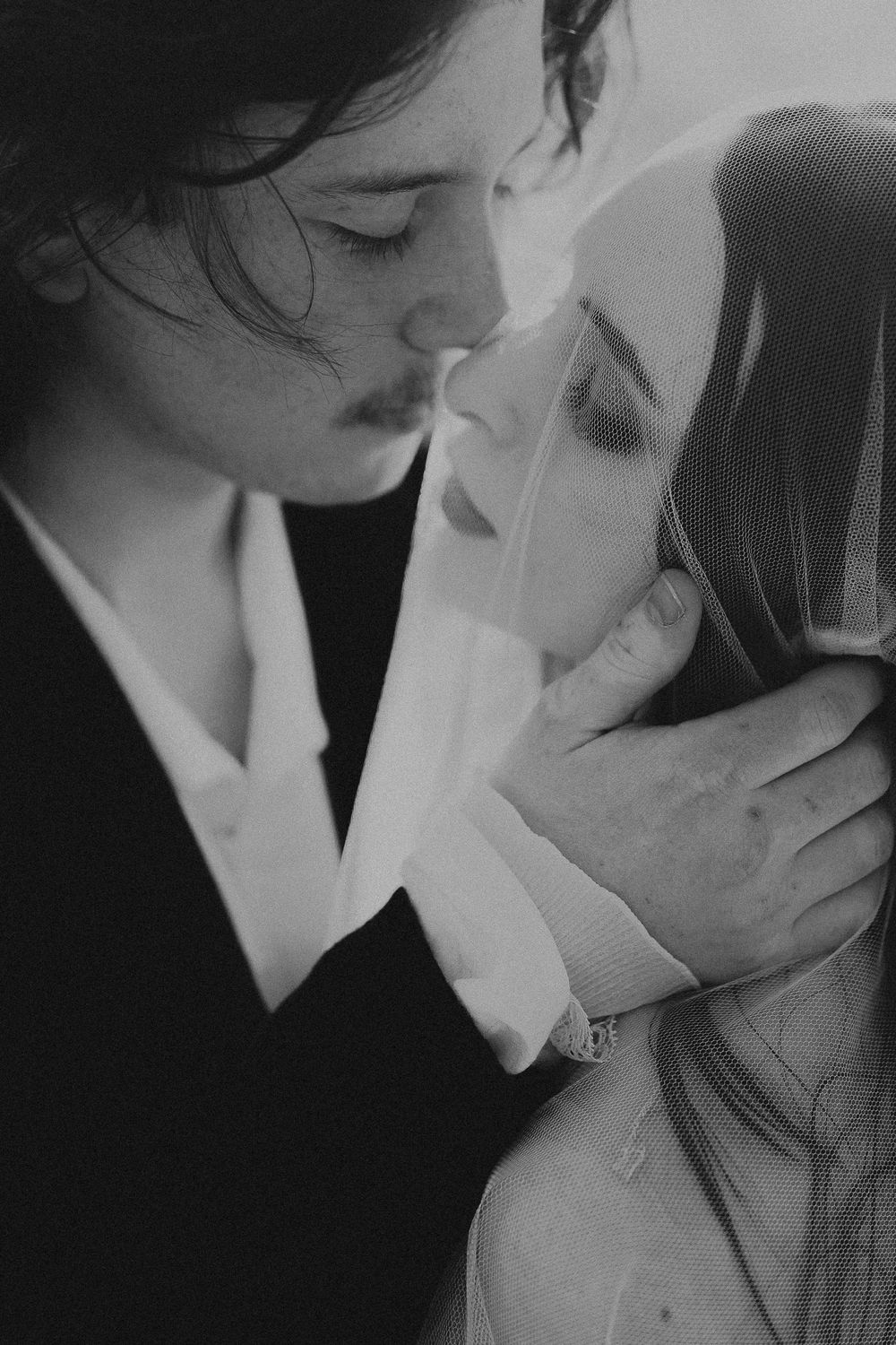 A romantic black and white close-up photograph of a tender intimate moment between two people.