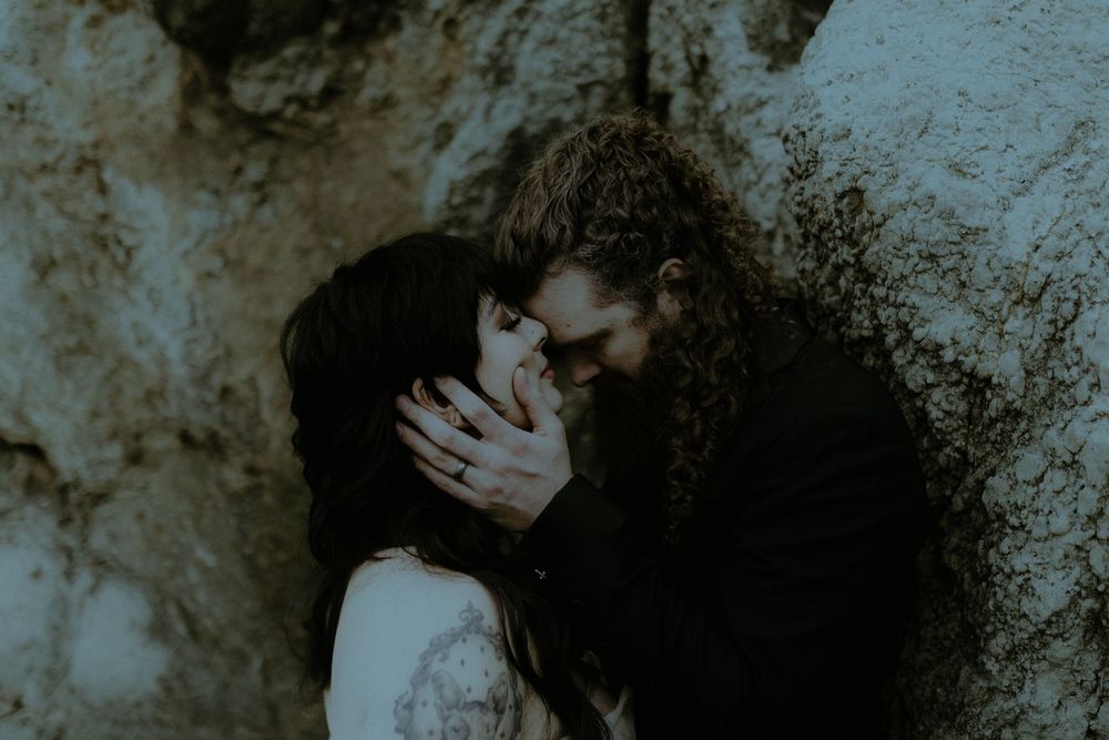 Intimate romantic moment captured against dark moody backdrop.