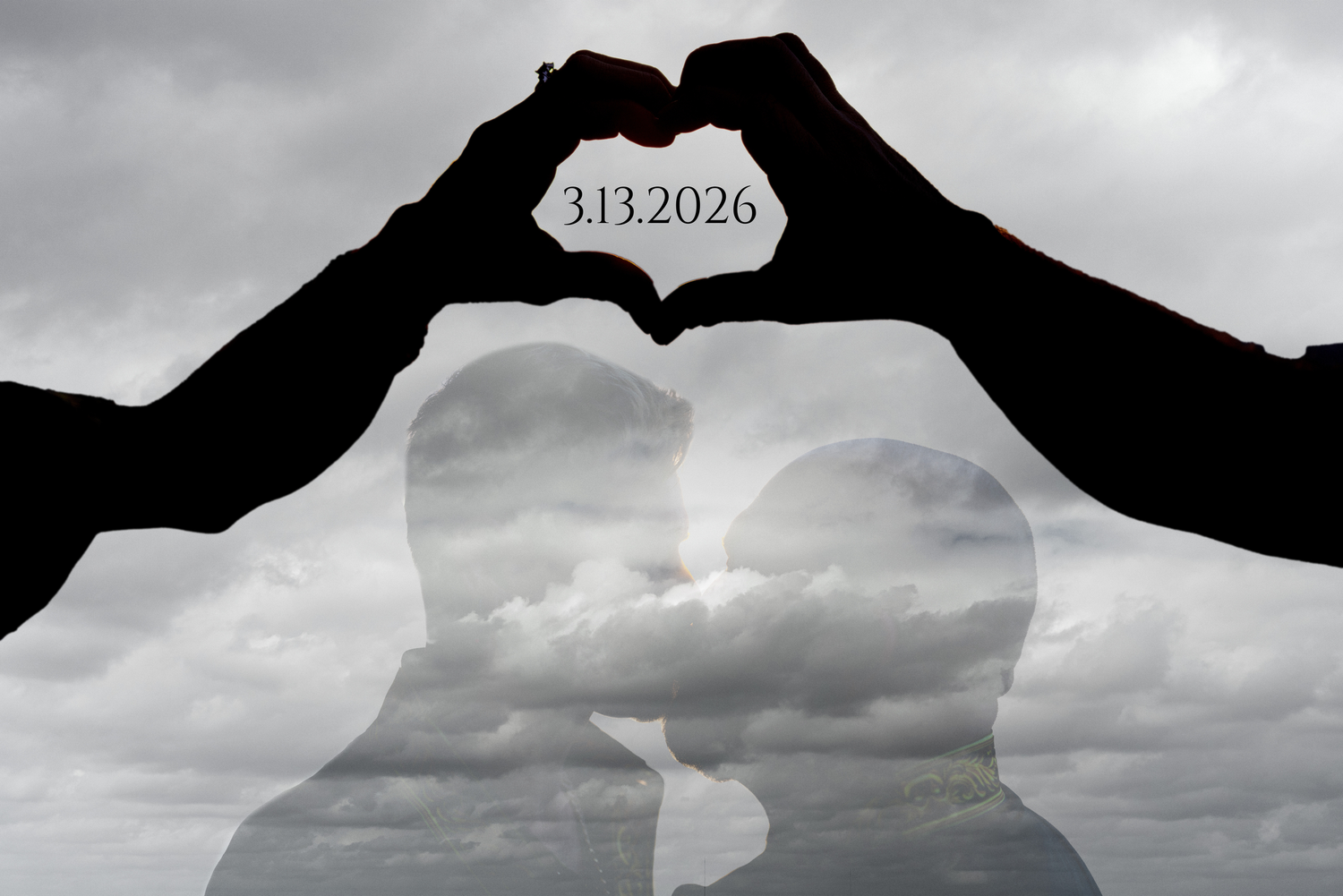 Silhouette of couple kissing inside heart-shaped hands with save the date 3.13.2026.