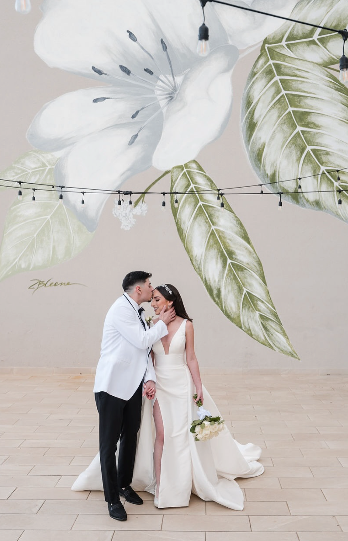 Bride and groom posing together in a modern studio setting with soft neutral tones