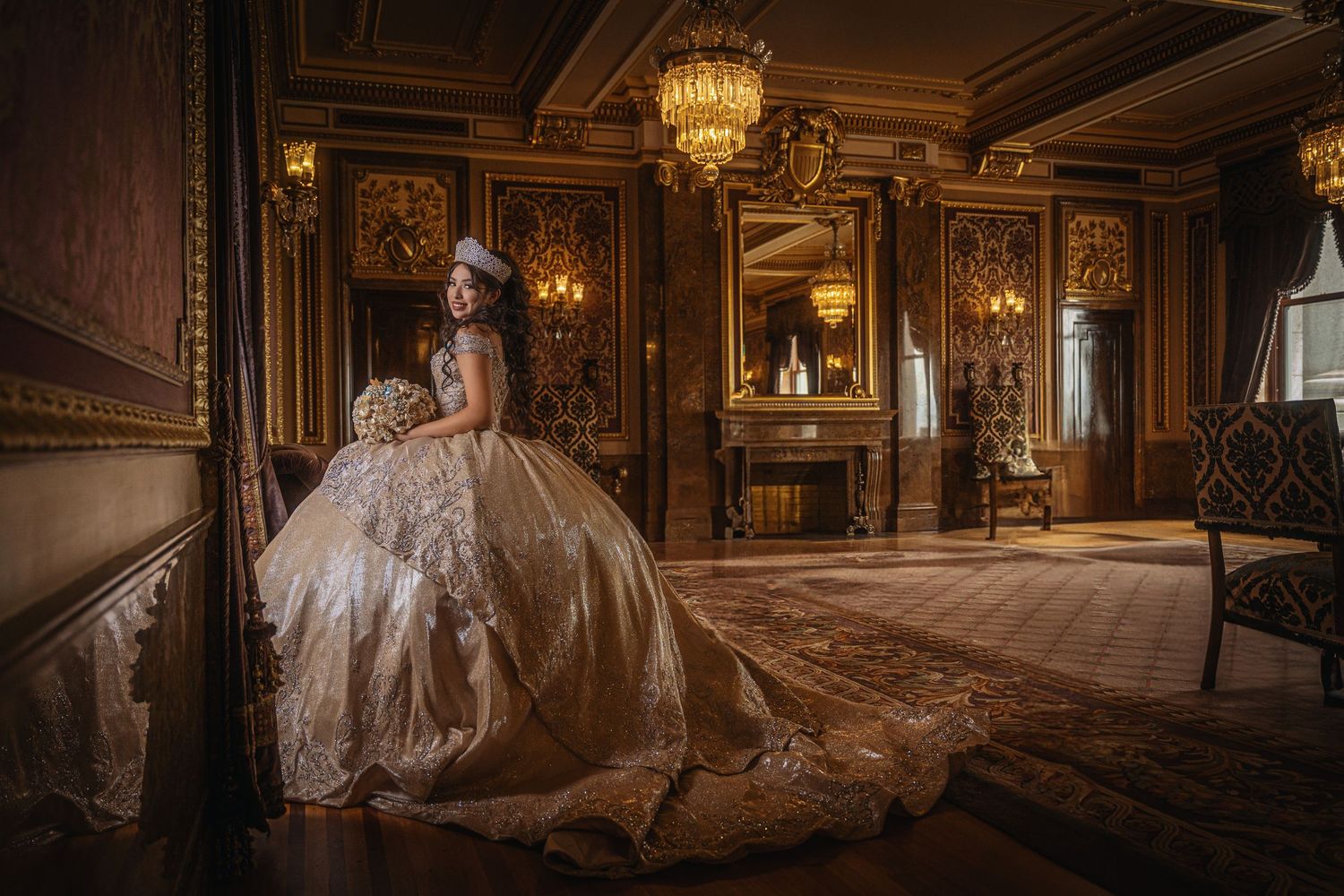 Young woman in an ornate golden ballgown poses in a luxurious wood-paneled room with chandeliers.