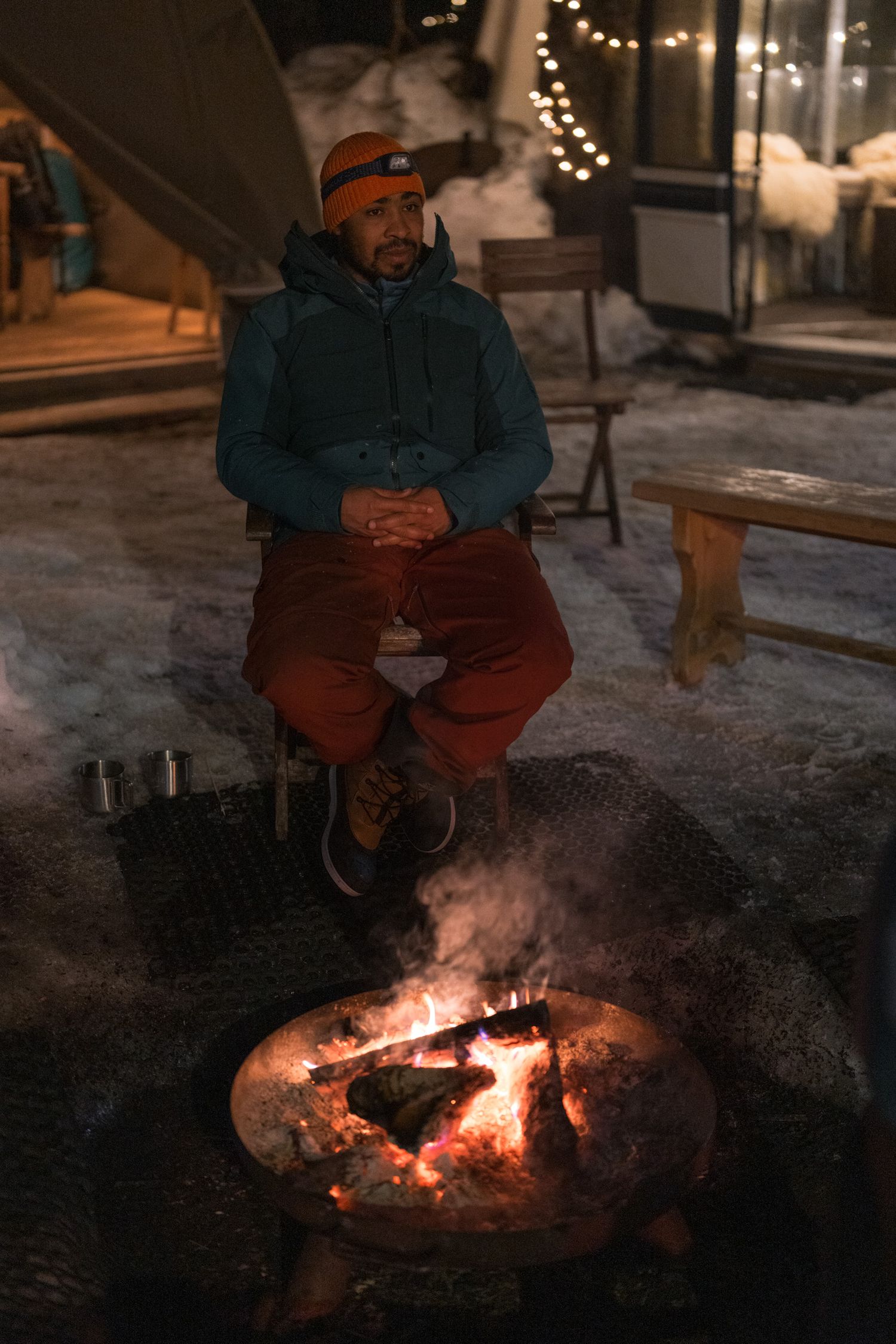 Photo d'un homme assis à côté d'un feu de camp à Anncecy