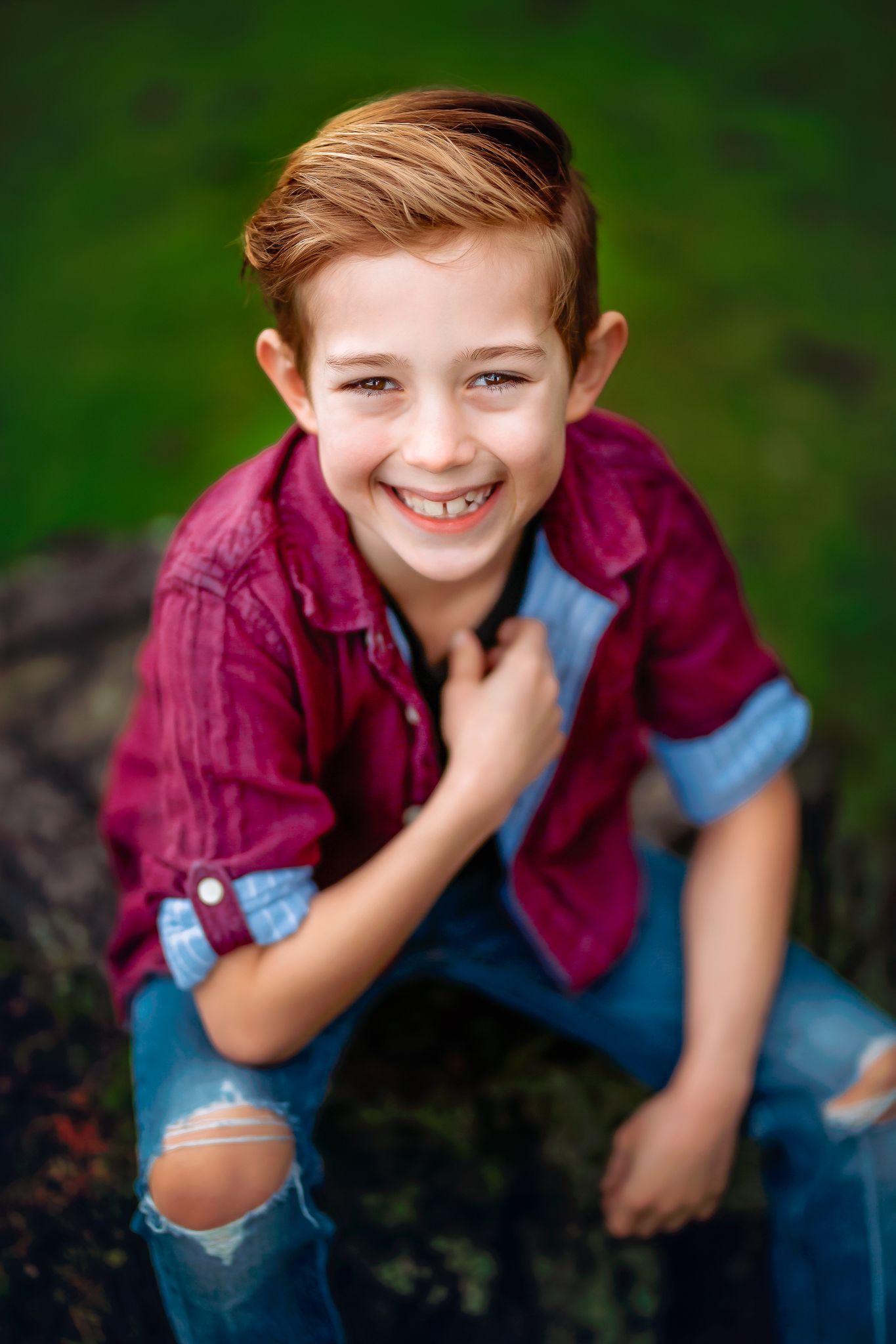 Boy sitting and smiling during outdoor family photo session
