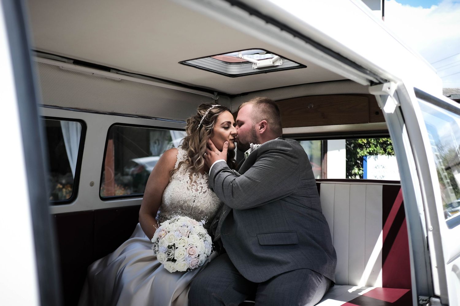 Bride and groom share an intimate kiss in a VW camper van at South Sands, North Somerset.