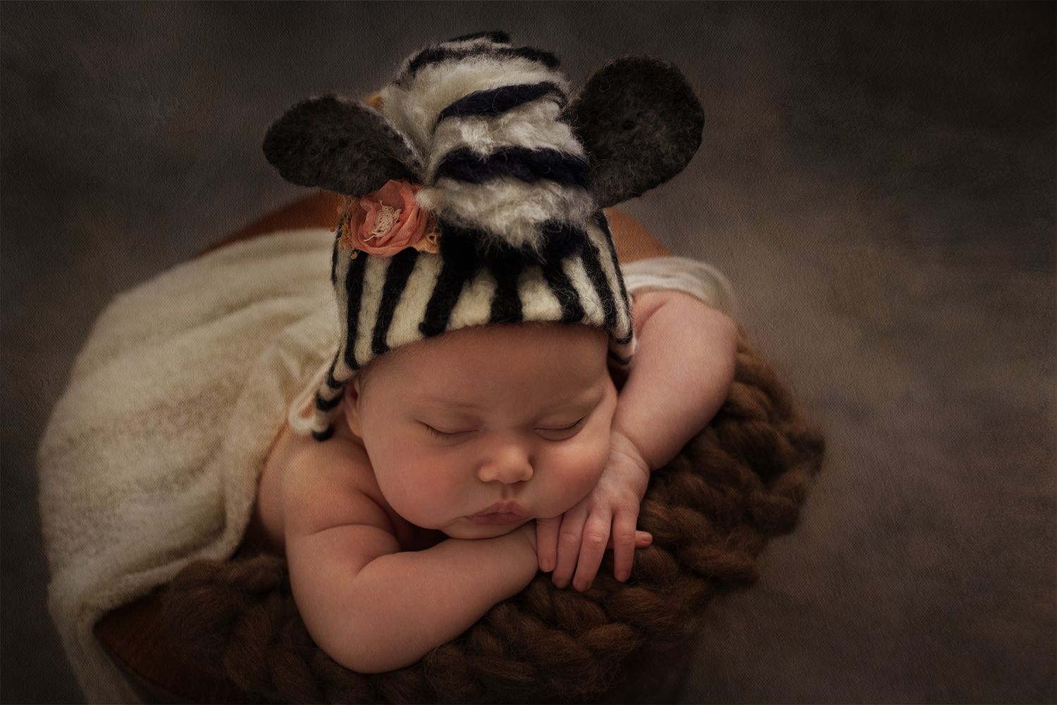 Ensaio newborn com bebê usando touca de zebra exclusiva, deitado de forma angelical em estúdio por Rose Carvalho.