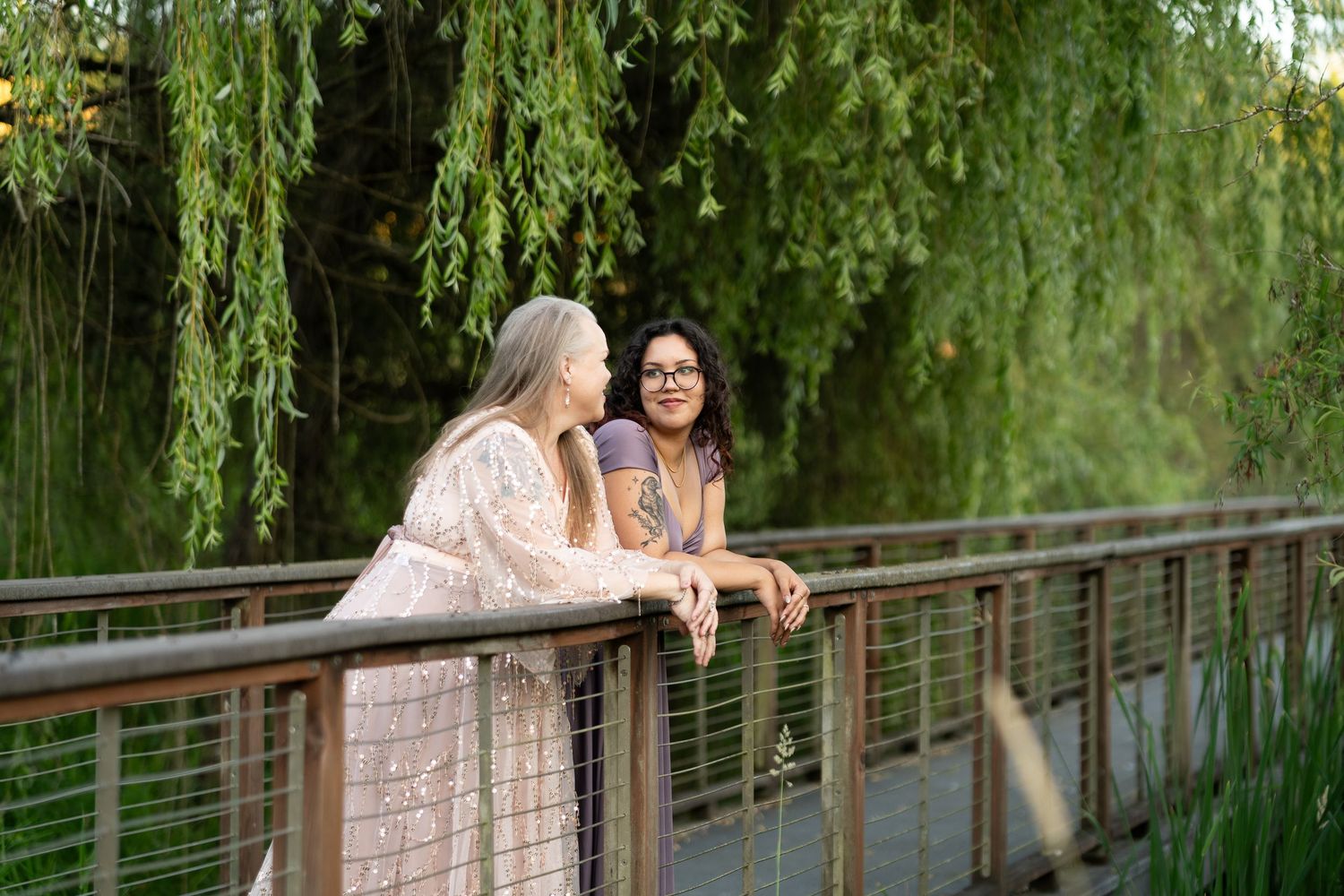 Casual outdoor photoshoot on wooden bridge with willow trees in background by Filling the Frame Photography at Brightwater Center Woodinvill