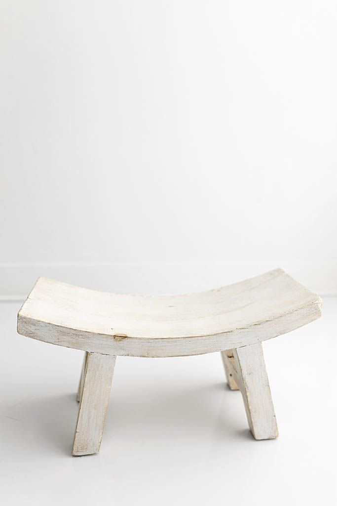 Rustic white painted wooden stool with curved seat, baby and child seating for professional studio photography.