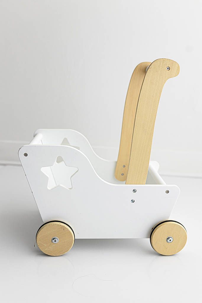 A white and natural wood toy baby walker with star cutout and wheels on white background.