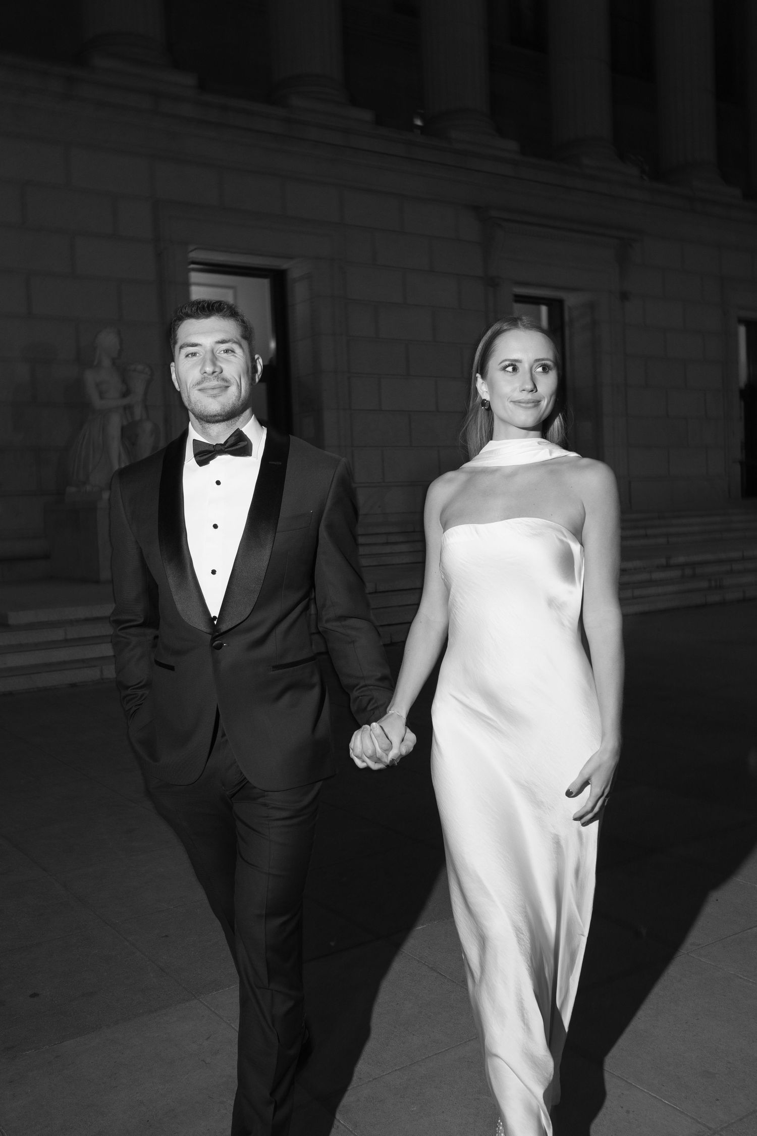 A black and white photo series shows a couple in formal attire walking together, with him in a tuxedo and her in white.