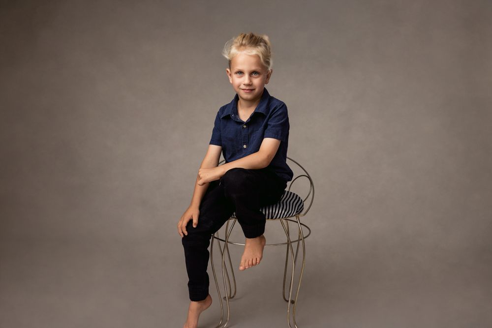 Classic family portrait, young man sitting on antique chair
