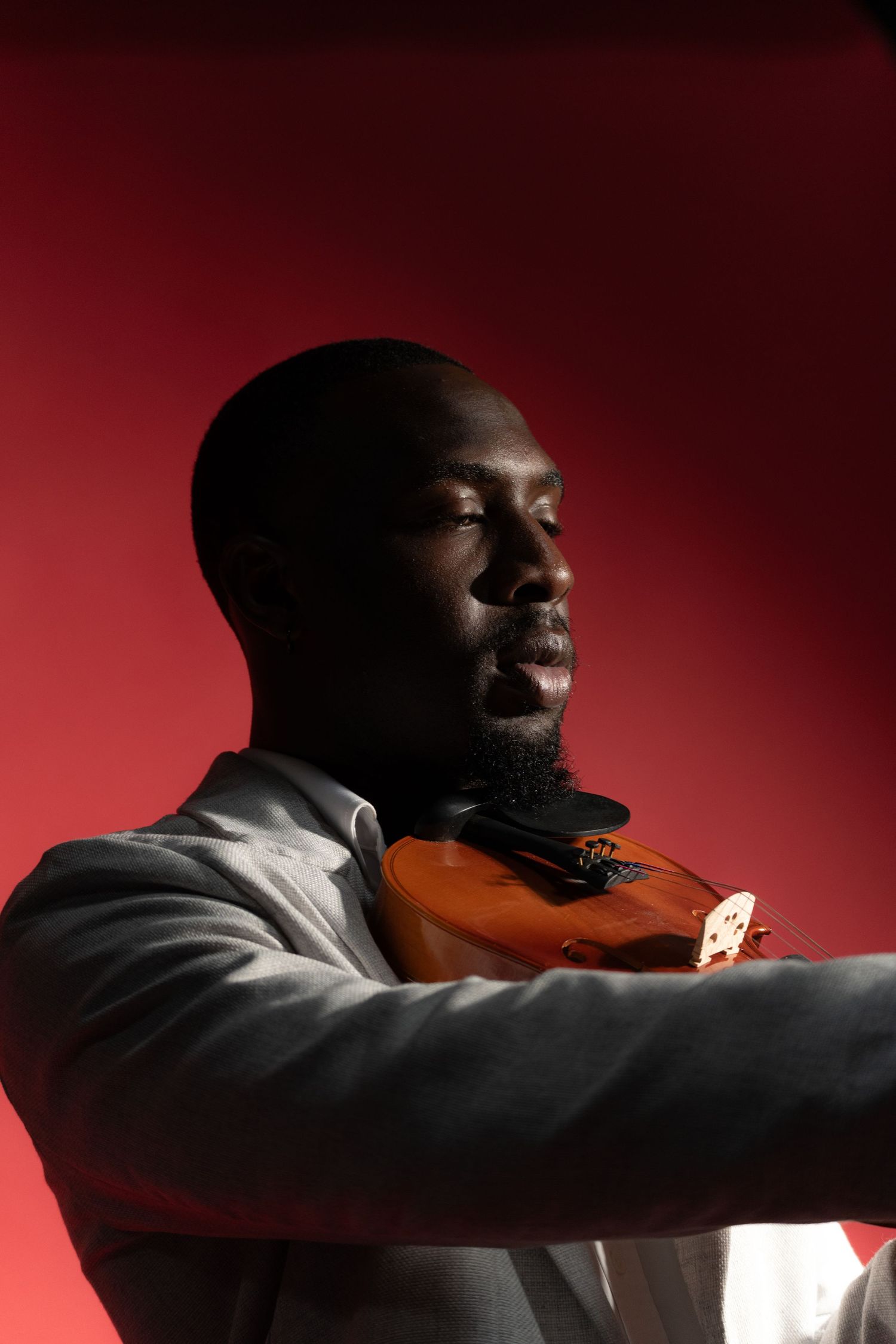 Close-up shot of violin player performing in dramatic lighting.