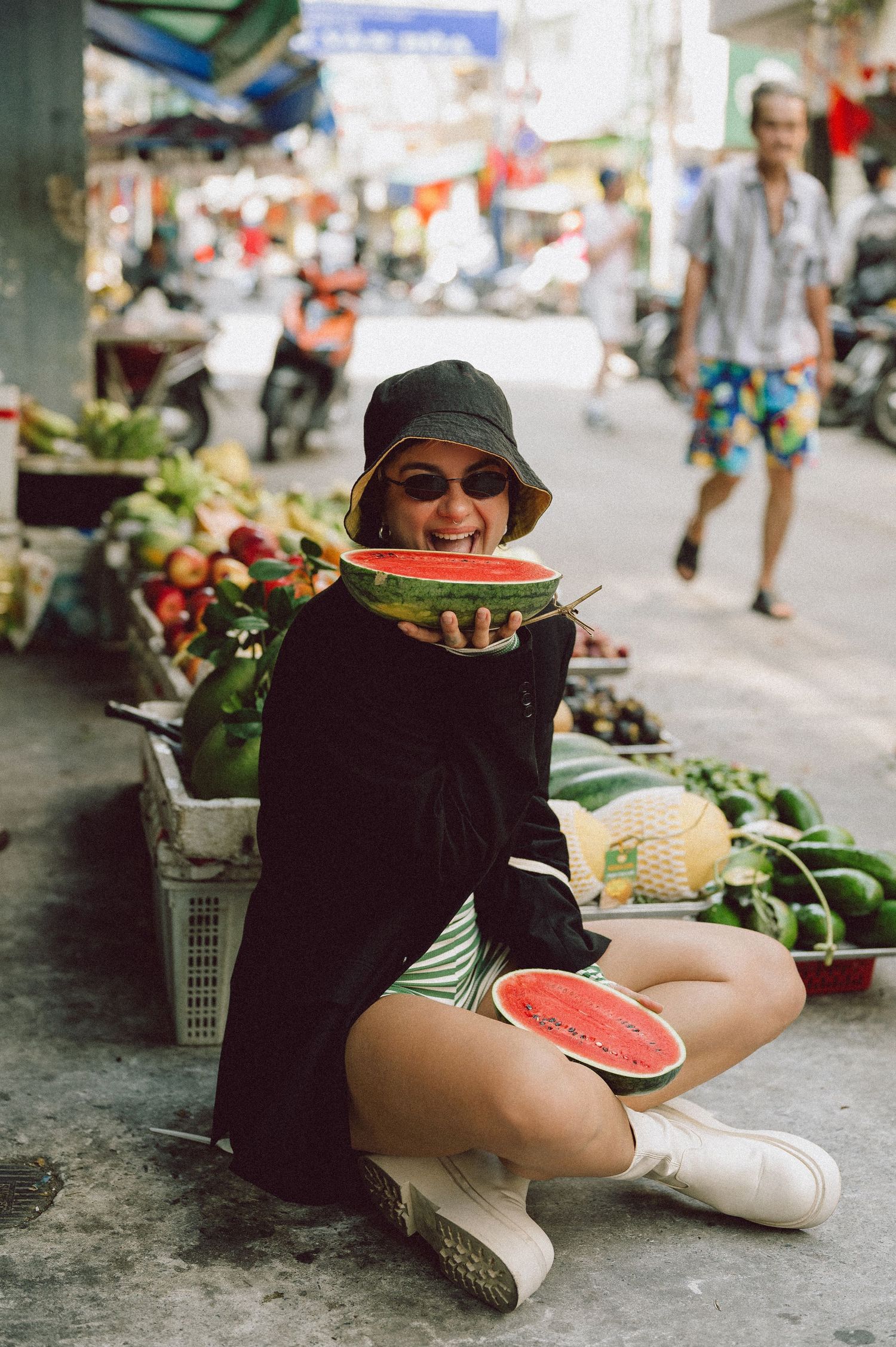 Model seated among fruit stalls at Banana Garden Market, Ho Chi Minh City — editorial lifestyle photography