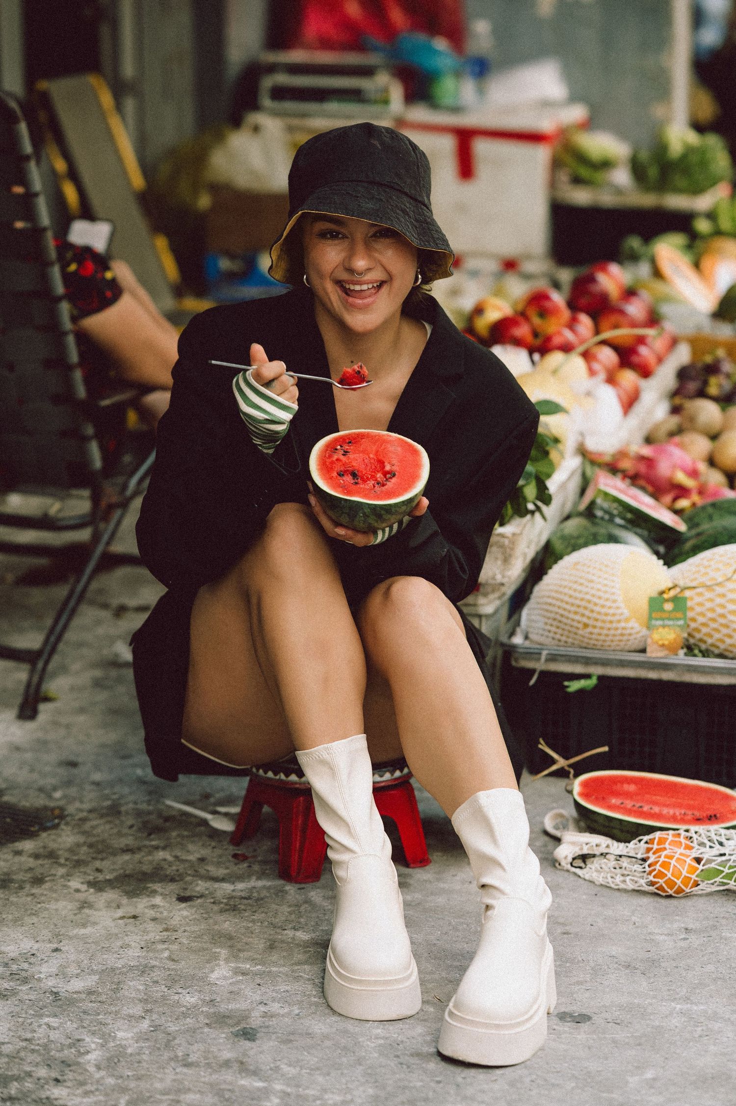 Model seated among fruit stalls at Banana Garden Market, Ho Chi Minh City — editorial lifestyle photography