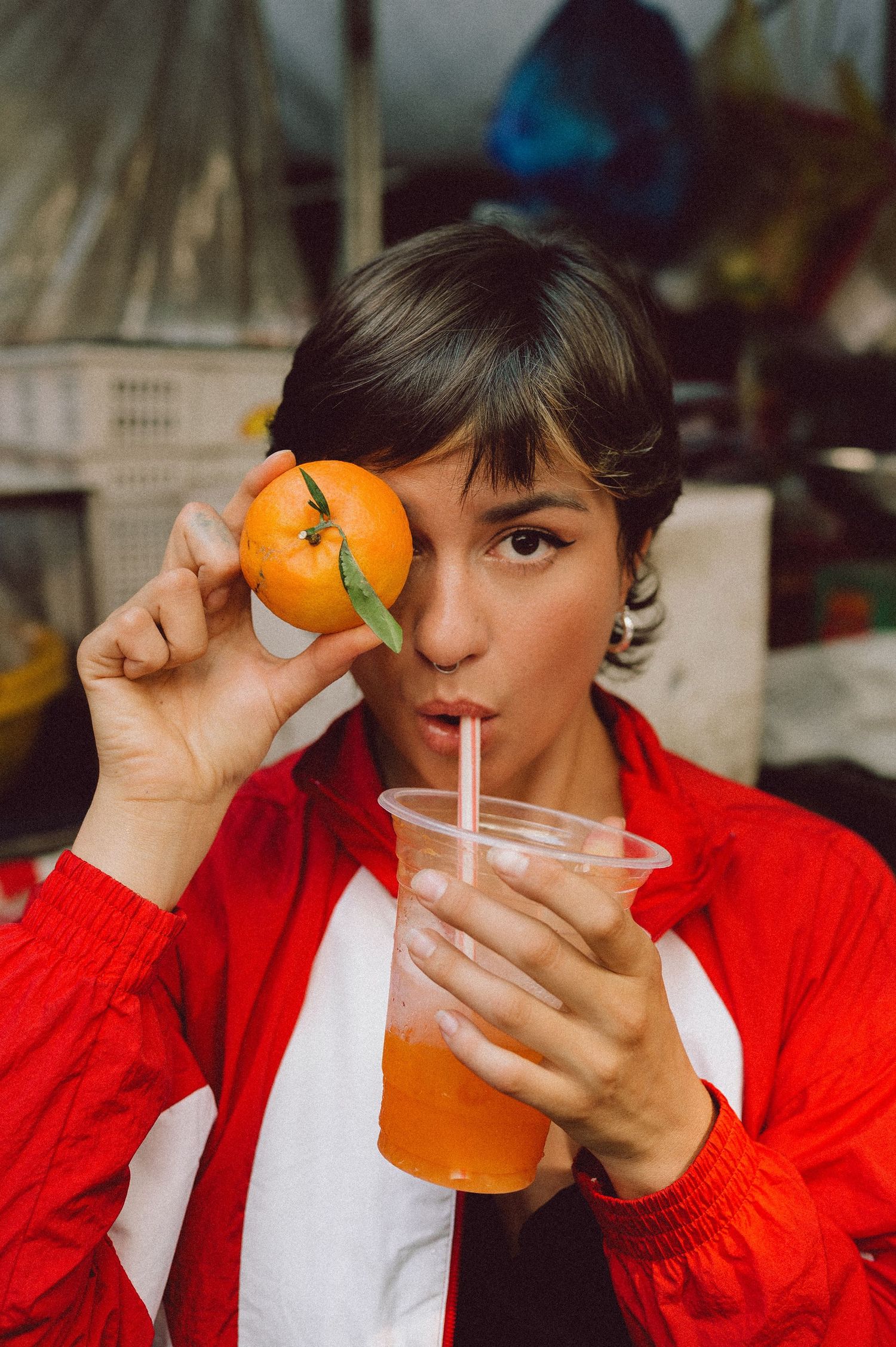 Model drinking fresh orange juice at a fruit stall in Saigon — candid editorial portrait photography by Anastasia Sokyrka