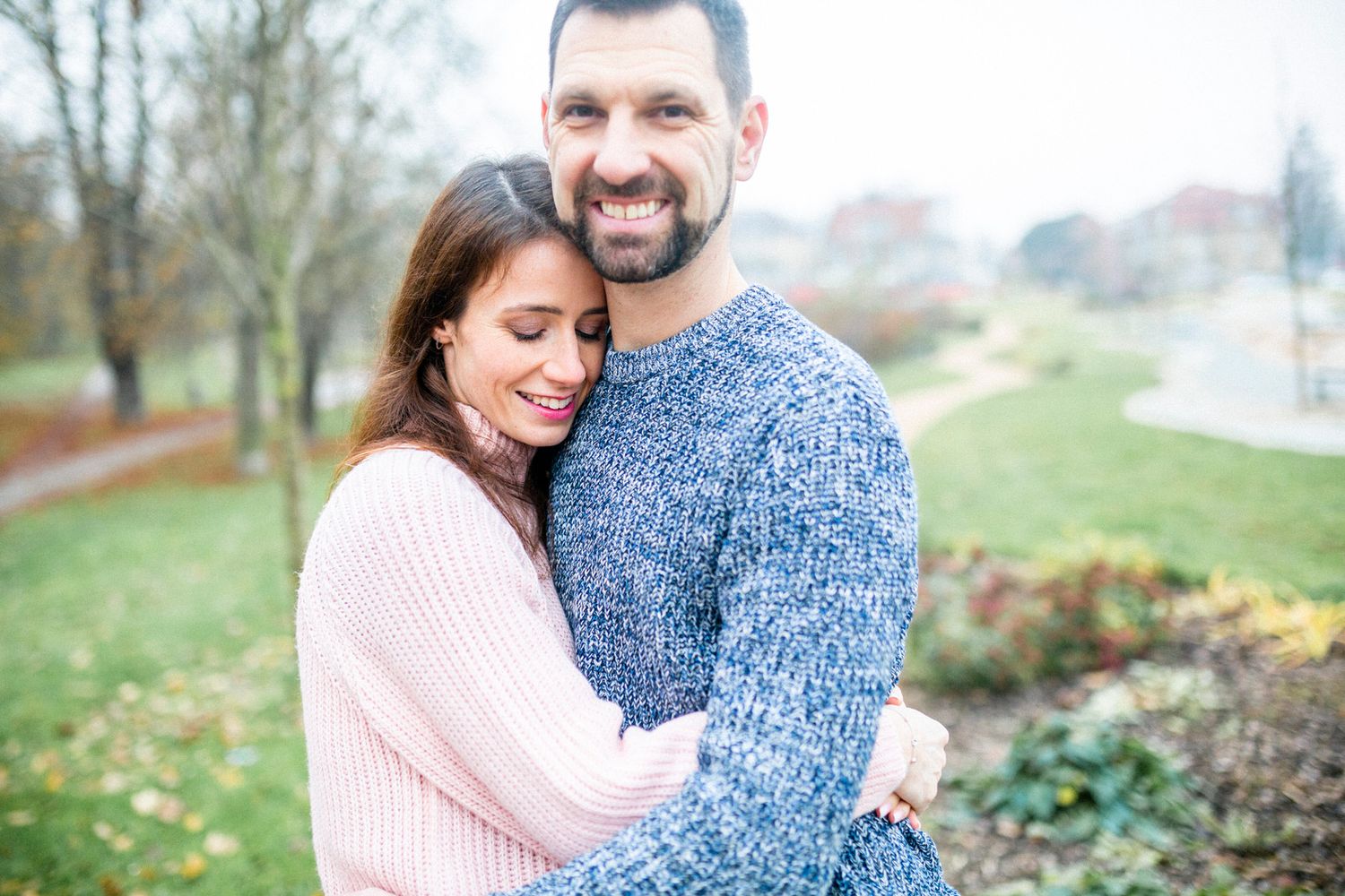 Happy couple sharing an intimate moment in a park during autumn.