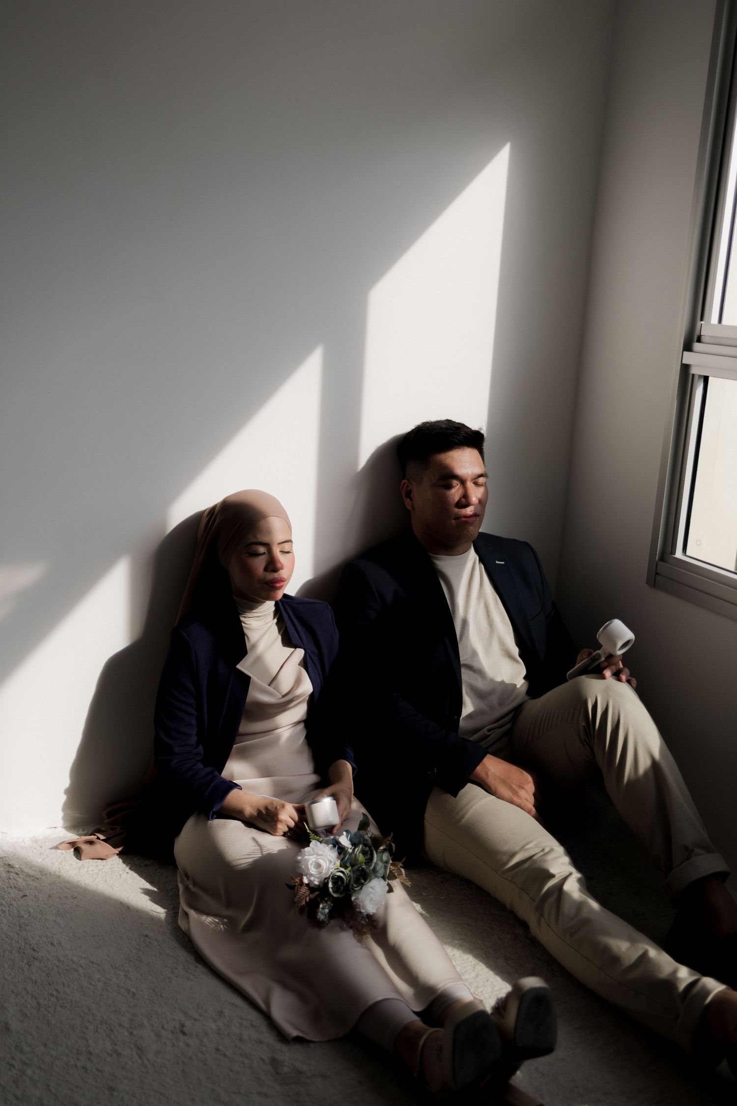 A creative wedding photoshoot under white arches with couples lying on the floor.