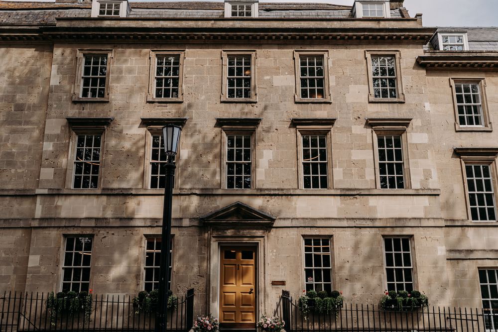 Historic Georgian stone building with elegant wooden door, black lamp post, and symmetrical sash windows in classic architecture.
