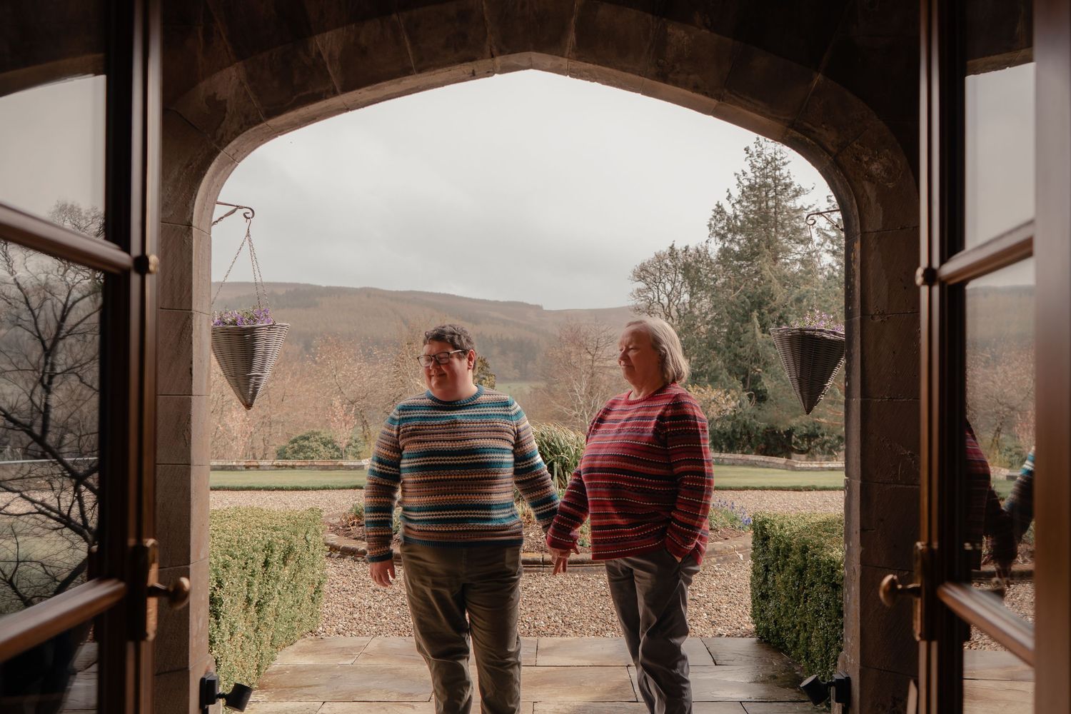 Couple at Stobo Castle photographed through open doors leading onto the terrace during their intimate Scotland wedding.