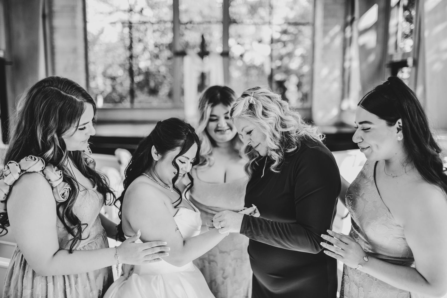 Bride surrounded by bridesmaids during wedding day preparations