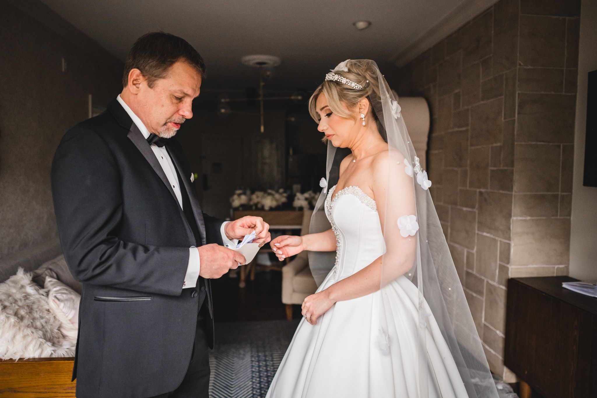 Bride and groom exchanging wedding rings indoors during a romantic wedding ceremony preparation.