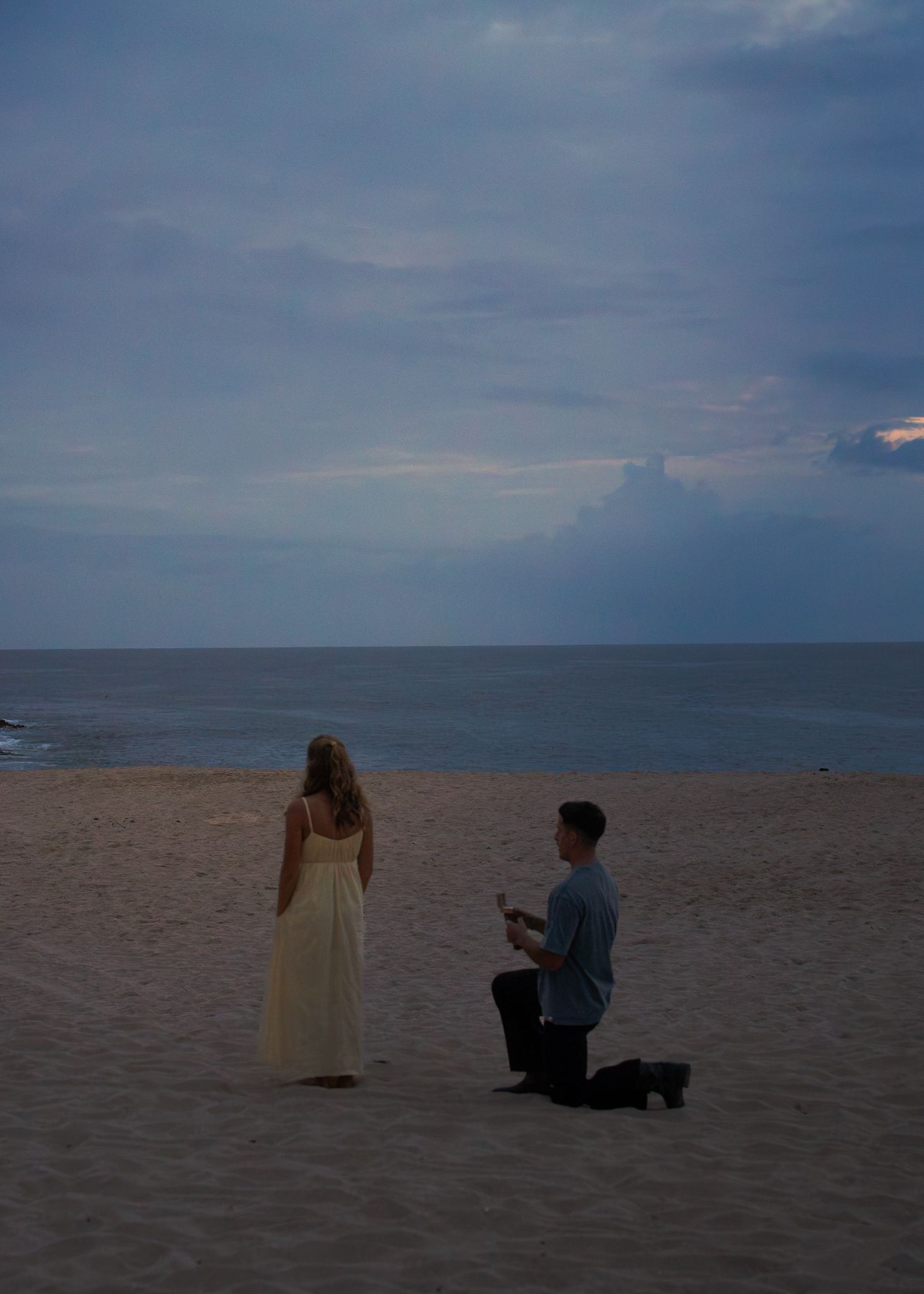 A sweet couple seconds before a surprise proposal on a beach in Hawaii.
