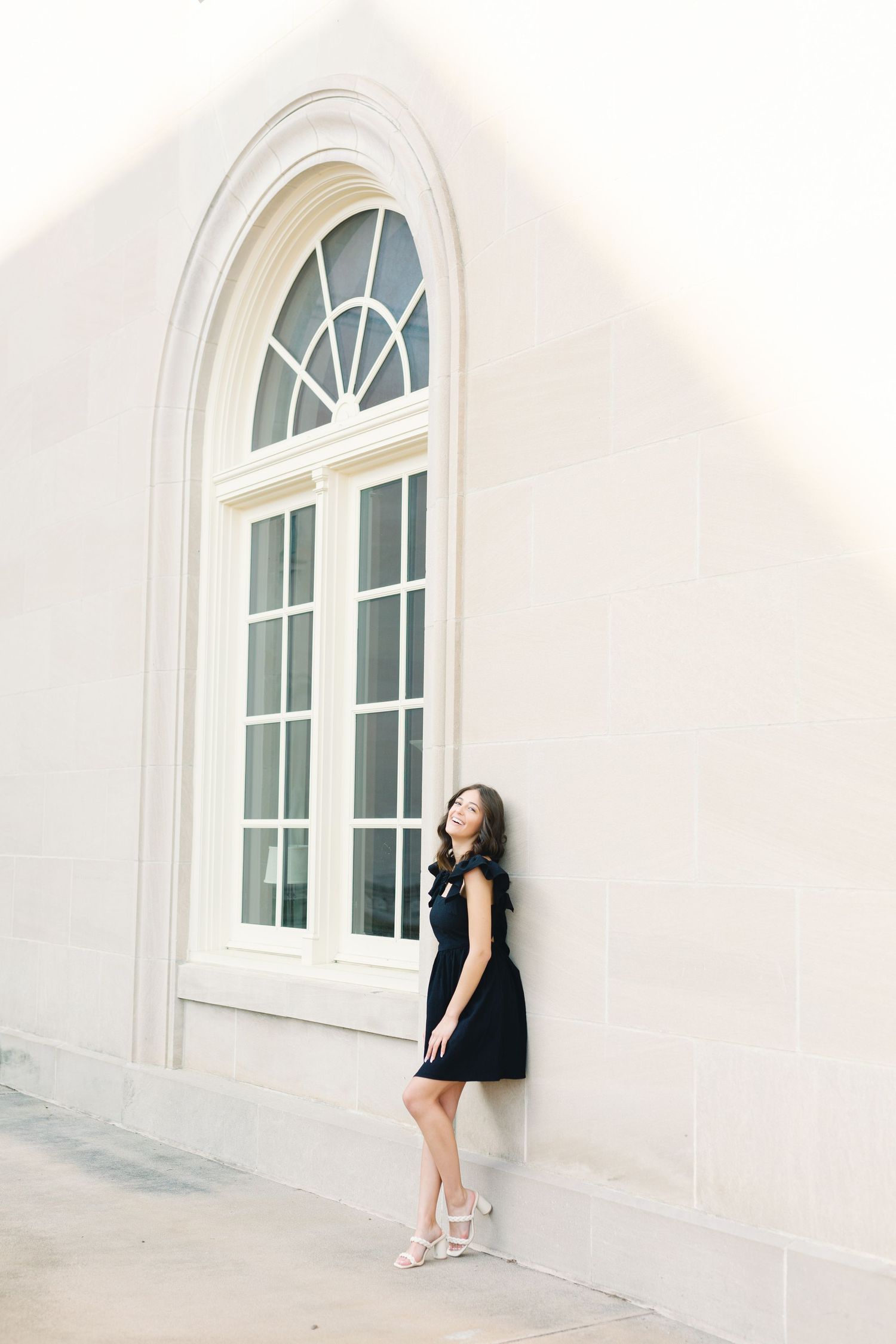 A portrait session against a white wall with arched windows showing dramatic poses.