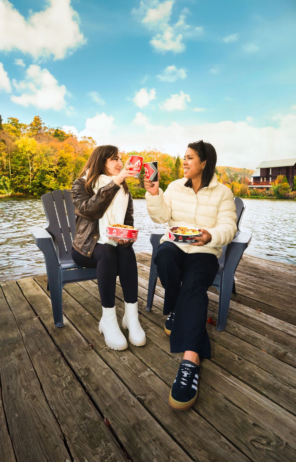 Two people enjoying takeout meals while sitting in Adirondack chairs on a lakeside dock. Mtlshutter photography