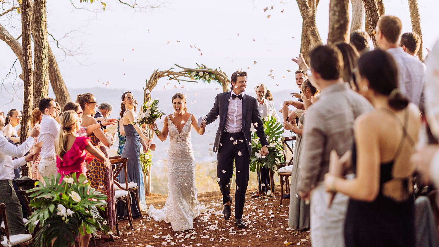 Wedding preparations scene with flowing white dress and pink bridesmaid dresses in an elegant room.