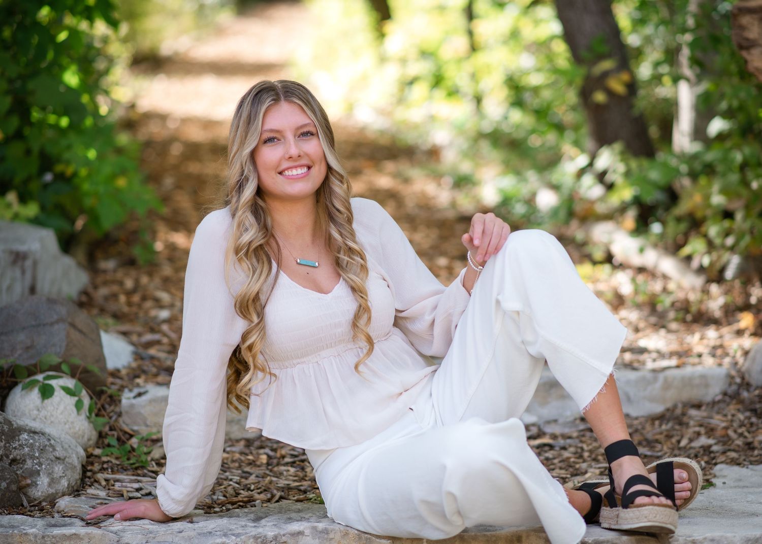 A series of outdoor portraits in white dress showing person reclining and sitting on stone steps in natural lighting.