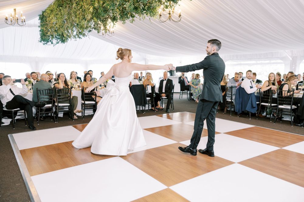 A wedding dance sequence showing intimate moments under a white tent reception with guests watching from their tables.